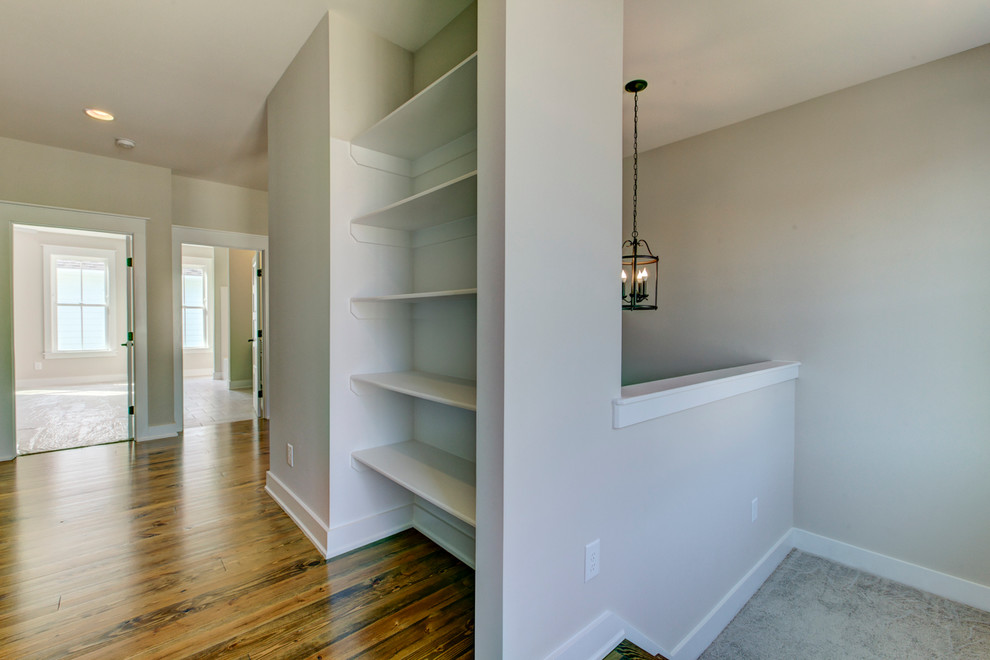 Design ideas for a mid-sized country hallway in Raleigh with grey walls and medium hardwood floors.