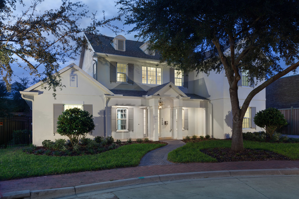 This is an example of a large traditional two-storey stucco white exterior in Orlando with a gable roof.