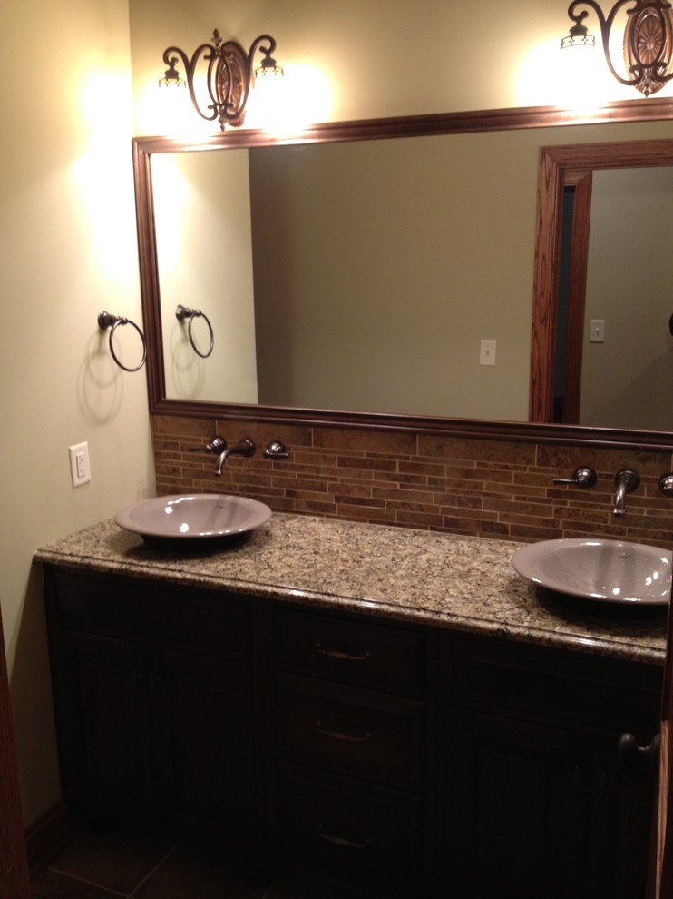 Inspiration for a mid-sized brown tile and ceramic tile bathroom remodel with a vessel sink, granite countertops and beige walls