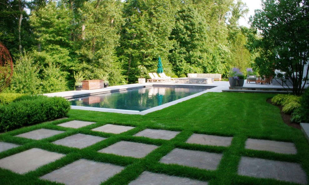 This is an example of a traditional backyard rectangular pool in New York with stamped concrete.