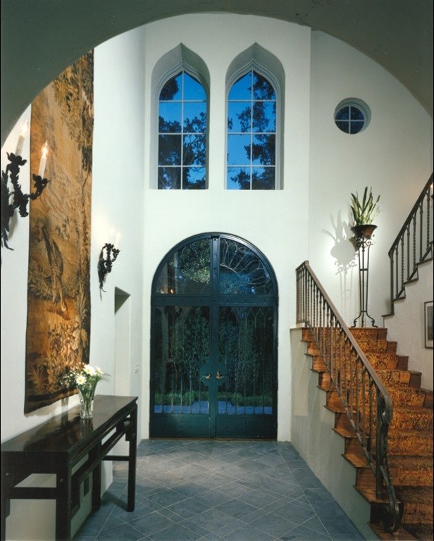 Inspiration for a large mediterranean foyer in Santa Barbara with white walls, slate floors, a double front door and a glass front door.