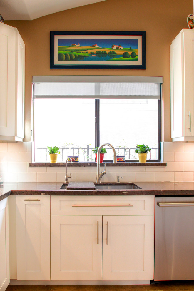 Mid-sized transitional u-shaped porcelain tile and brown floor eat-in kitchen photo in Phoenix with an undermount sink, shaker cabinets, white cabinets, white backsplash, subway tile backsplash, stainless steel appliances, an island, granite countertops and brown countertops