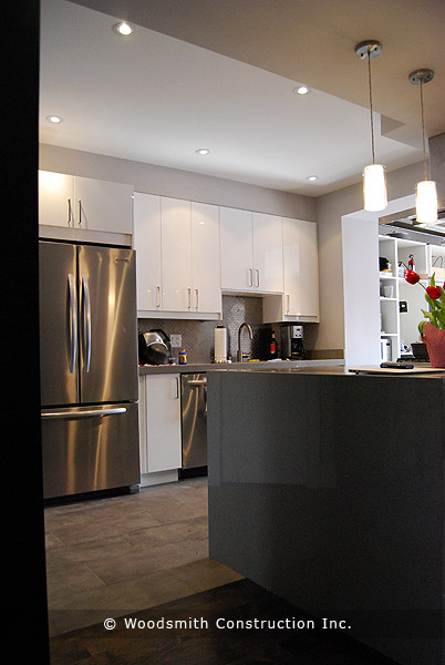 Small contemporary galley eat-in kitchen in Toronto with flat-panel cabinets, white cabinets, concrete benchtops, metallic splashback, porcelain splashback and with island.