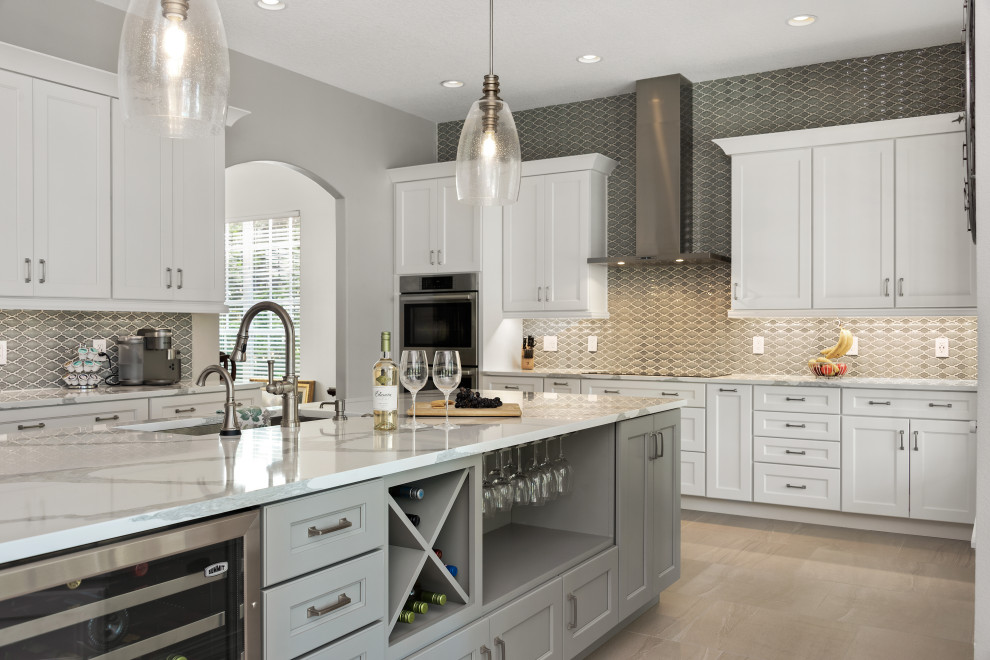 Inspiration for a large country l-shaped open plan kitchen in Orlando with an undermount sink, shaker cabinets, white cabinets, quartz benchtops, grey splashback, porcelain splashback, stainless steel appliances, ceramic floors, with island, grey floor and grey benchtop.