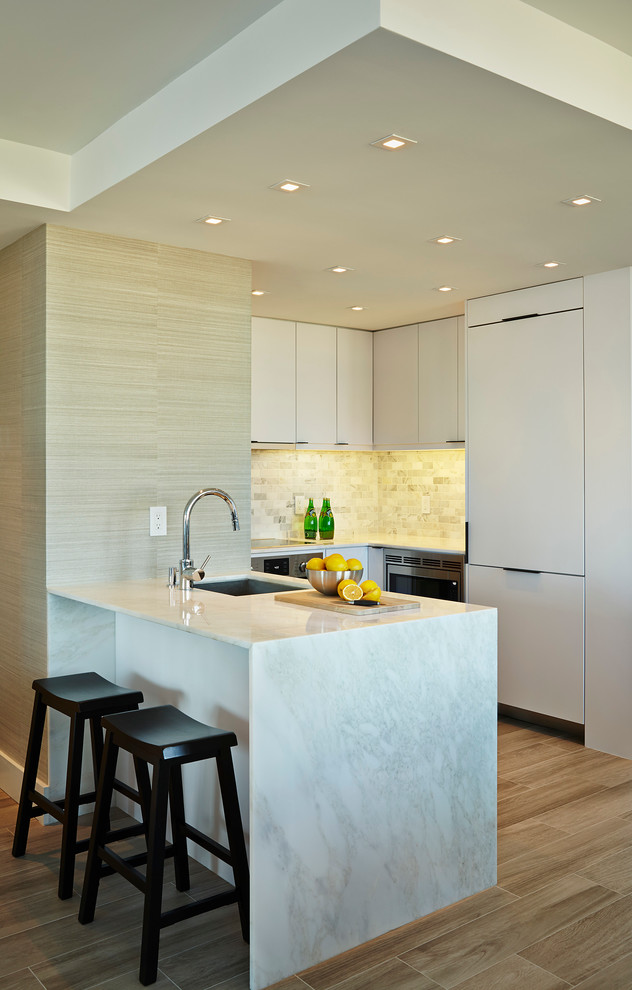 Contemporary galley eat-in kitchen in Miami with flat-panel cabinets, white cabinets, light hardwood floors and no island.
