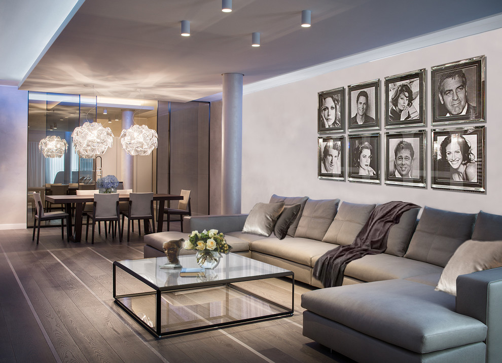 Photo of a large contemporary open concept living room in Milan with beige walls and light hardwood floors.