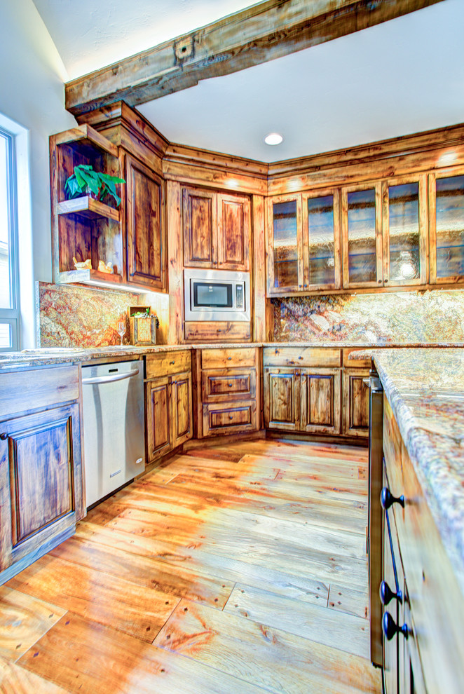 Kitchen pantry - large rustic u-shaped medium tone wood floor kitchen pantry idea with a drop-in sink, glass-front cabinets, medium tone wood cabinets, beige backsplash, stainless steel appliances and an island