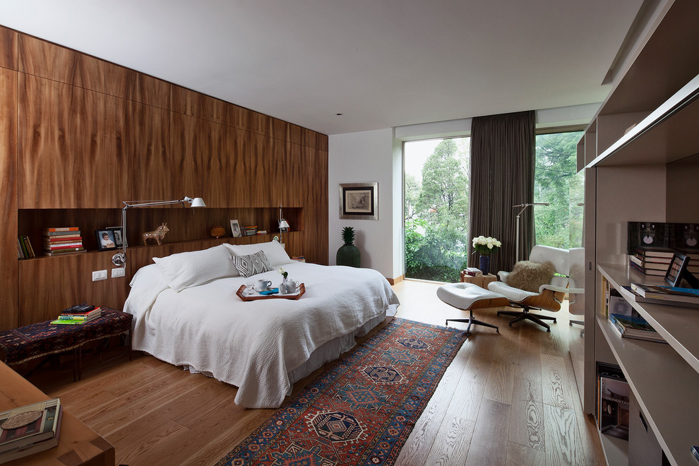This is an example of a contemporary bedroom in Mexico City with white walls and medium hardwood floors.