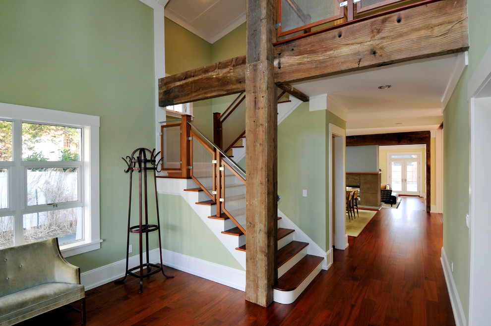 Photo of a large arts and crafts wood u-shaped staircase in New York with painted wood risers.