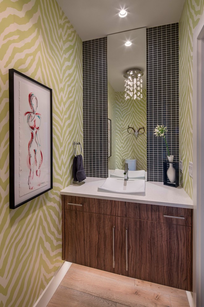 This is an example of a contemporary powder room in Austin with flat-panel cabinets, black tile, multi-coloured walls, light hardwood floors, a vessel sink and dark wood cabinets.