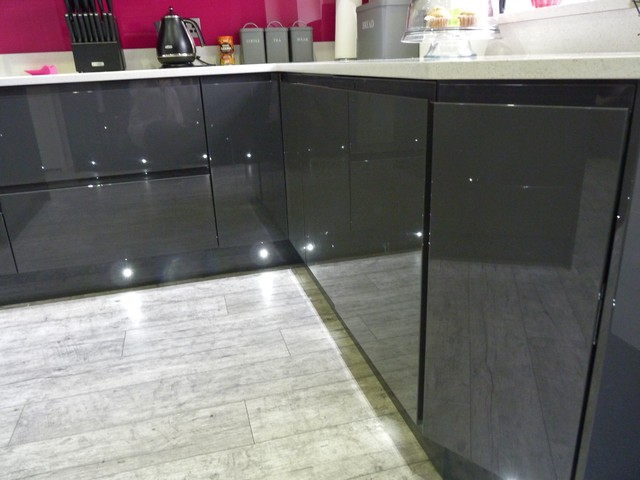 Gloss lacquered 'graphite' handleless kitchen with white quartz worktops contemporaneo-cocina