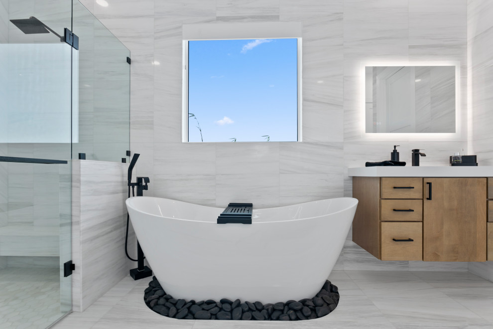 Cette image montre une grande salle de bain principale design avec placards, des portes de placard grises, une baignoire indépendante, une douche à l'italienne, tous types de WC, un carrelage blanc, du carrelage en marbre, un mur gris, un sol en marbre, un lavabo encastré, un plan de toilette en quartz, un sol blanc, une cabine de douche à porte battante, un plan de toilette blanc, un banc de douche, meuble double vasque, meuble-lavabo suspendu, différents designs de plafond et différents habillages de murs.