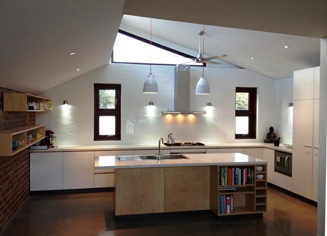 Inspiration for a mid-sized contemporary l-shaped open plan kitchen in Melbourne with a double-bowl sink, recessed-panel cabinets, light wood cabinets, quartz benchtops, white splashback, glass sheet splashback, stainless steel appliances, concrete floors, with island, brown floor and white benchtop.