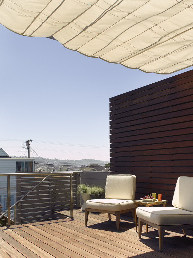 This is an example of a mid-sized contemporary backyard deck in San Francisco with an awning.