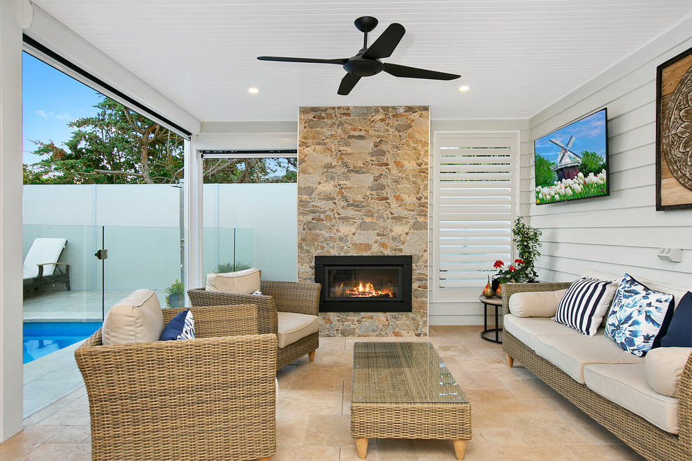 Inspiration for a beach style backyard patio in Melbourne with with fireplace and a roof extension.