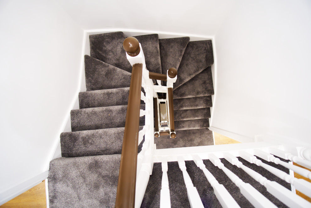 Aménagement d'un escalier sans contremarche courbe classique de taille moyenne avec un garde-corps en bois et des marches en moquette.
