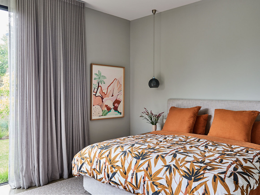 Foto de dormitorio principal exótico de tamaño medio con paredes grises, suelo de cemento y suelo gris