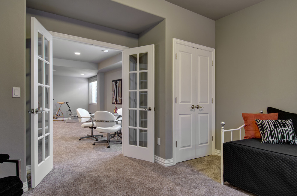 This is an example of a mid-sized transitional look-out basement in Denver with grey walls, carpet, no fireplace and beige floor.