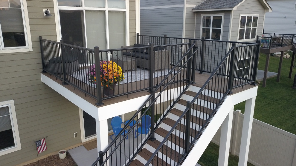 Small transitional backyard and first floor deck in Minneapolis with with skirting, no cover and metal railing.