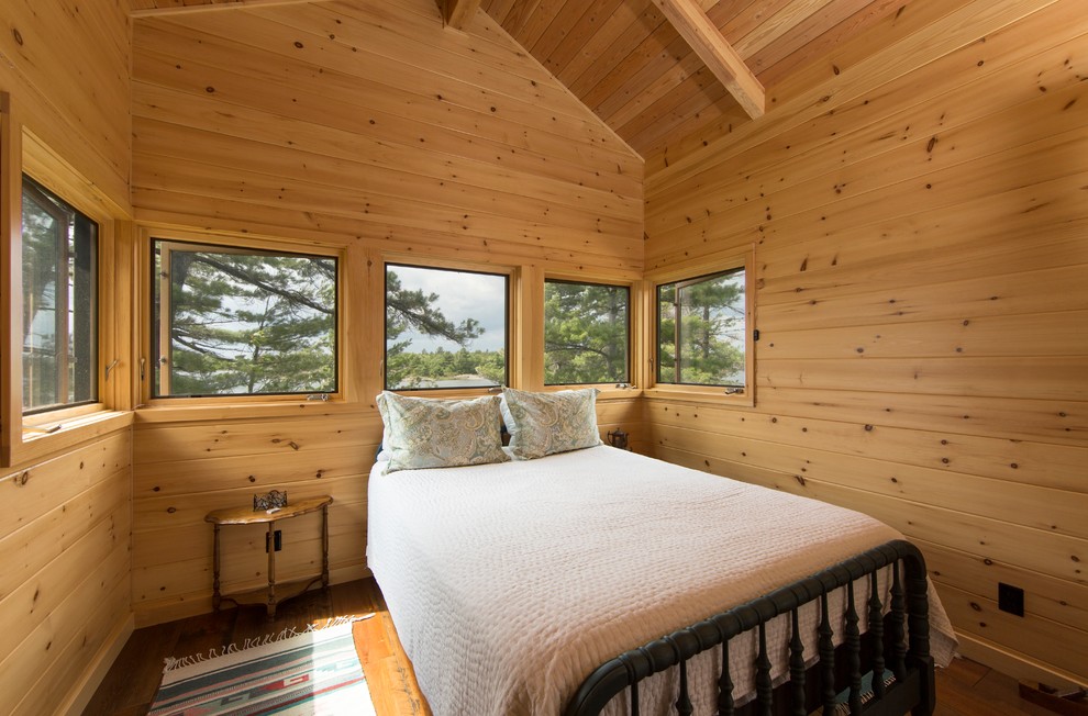Inspiration for a mid-sized country master bedroom in Other with medium hardwood floors, no fireplace and brown floor.