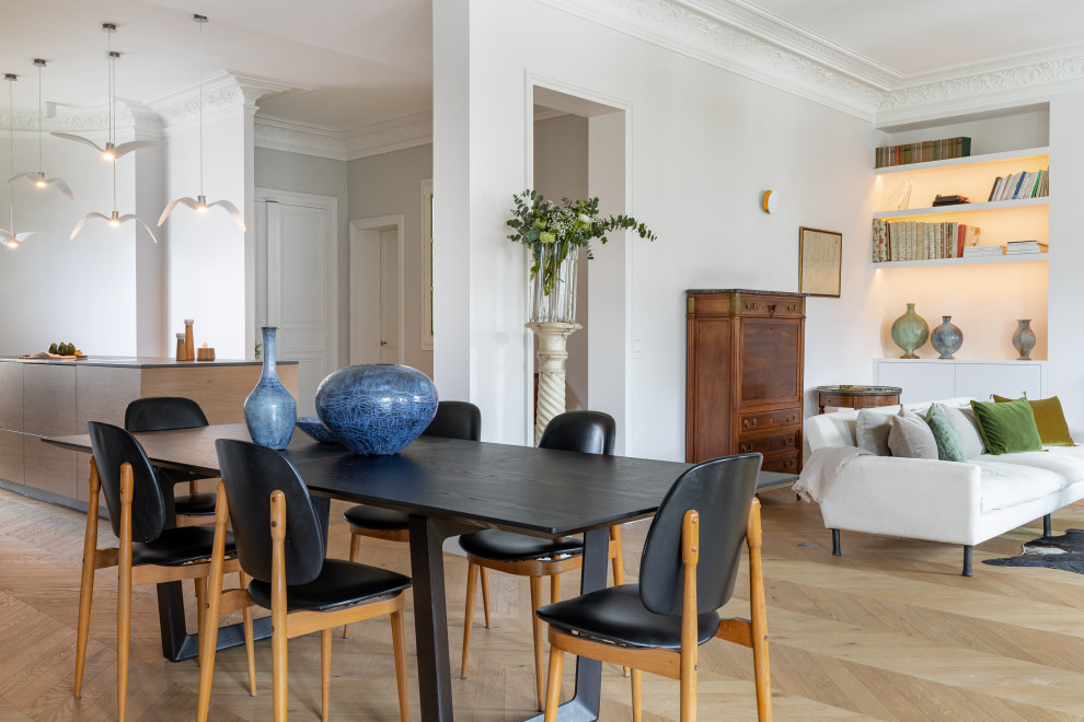 This is an example of a large contemporary open plan dining in Paris with white walls, light hardwood floors and beige floor.