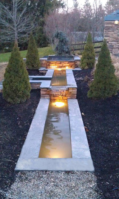Inspiration for a transitional backyard partial sun formal garden for spring in New York with with waterfall and natural stone pavers.