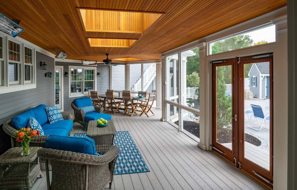 Inspiration for a large transitional backyard screened-in verandah in Boston with a roof extension and decking.