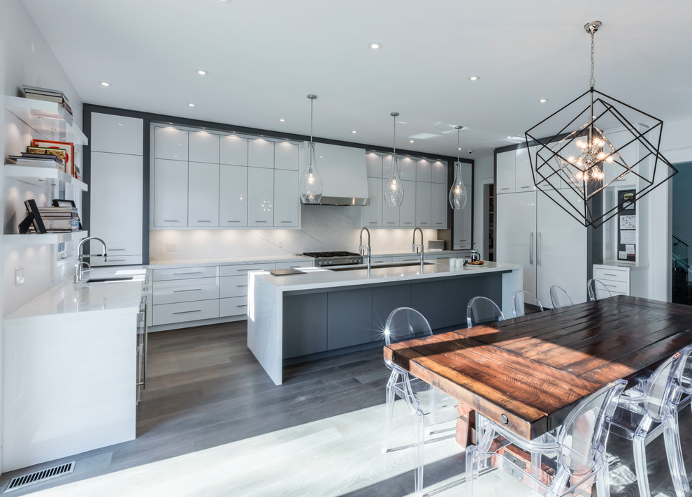 Photo of a large contemporary u-shaped eat-in kitchen in Toronto with flat-panel cabinets, white cabinets, marble benchtops, white splashback, stone slab splashback, stainless steel appliances, with island, an undermount sink and dark hardwood floors.