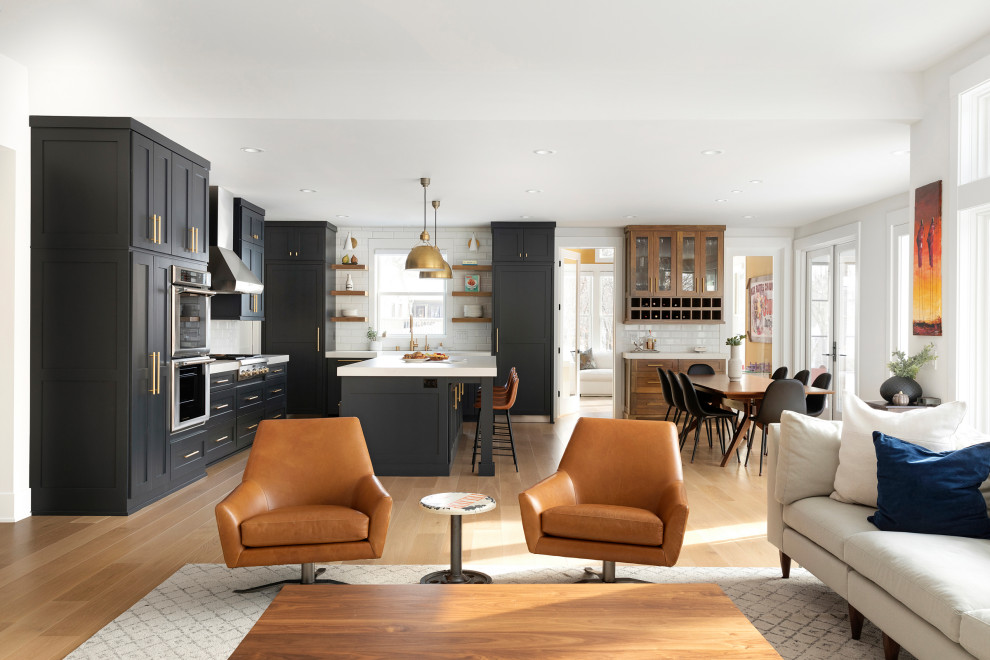Example of a transitional light wood floor and brown floor eat-in kitchen design in Minneapolis with a farmhouse sink, blue cabinets, quartz countertops, white backsplash, ceramic backsplash, stainless steel appliances, an island and white countertops