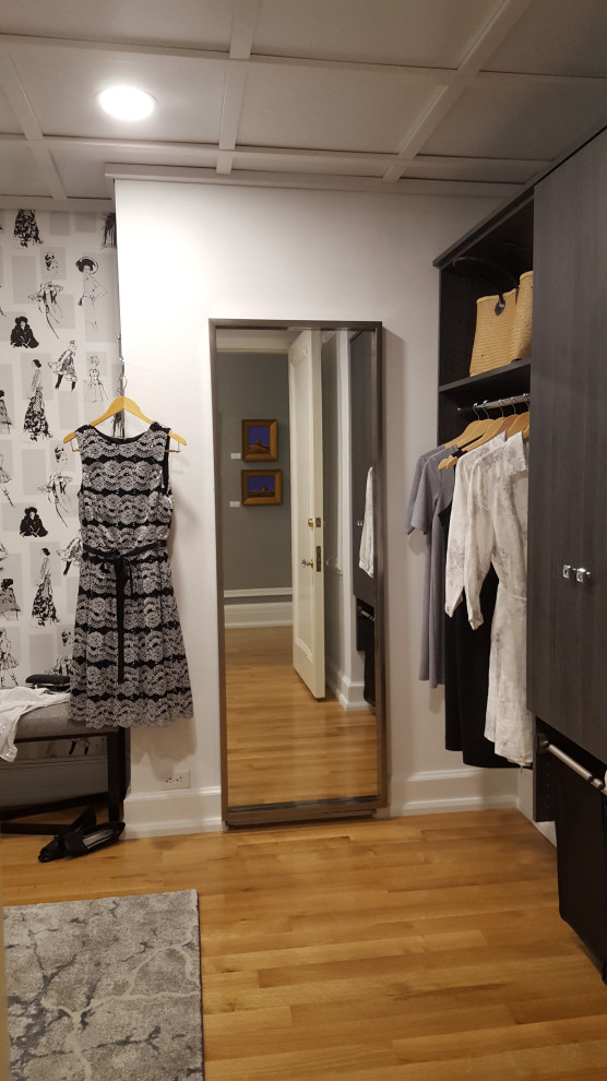Ejemplo de armario vestidor de mujer tradicional renovado de tamaño medio con armarios con paneles lisos, puertas de armario de madera en tonos medios, suelo de madera clara y casetón