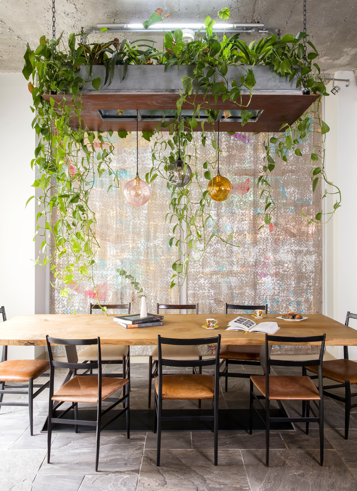 Inspiration for a mid-sized eclectic dining room in London with white walls and grey floor.