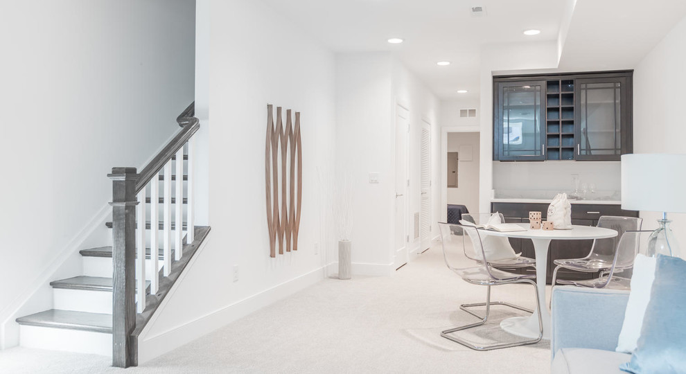 Modern look-out basement in DC Metro with white walls and carpet.