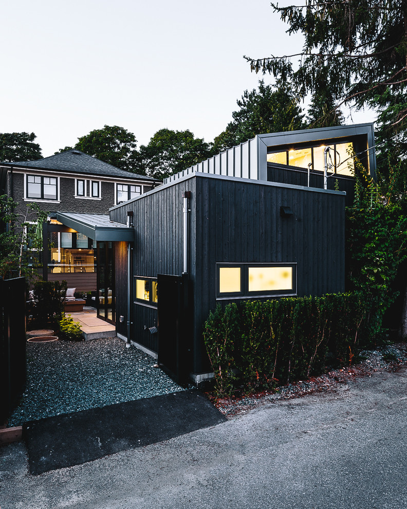 Ejemplo de fachada de casa negra nórdica de tamaño medio de una planta con revestimiento de madera
