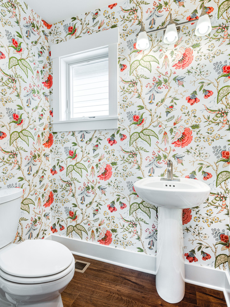Idée de décoration pour un petit WC et toilettes craftsman avec parquet foncé, meuble-lavabo sur pied et du papier peint.