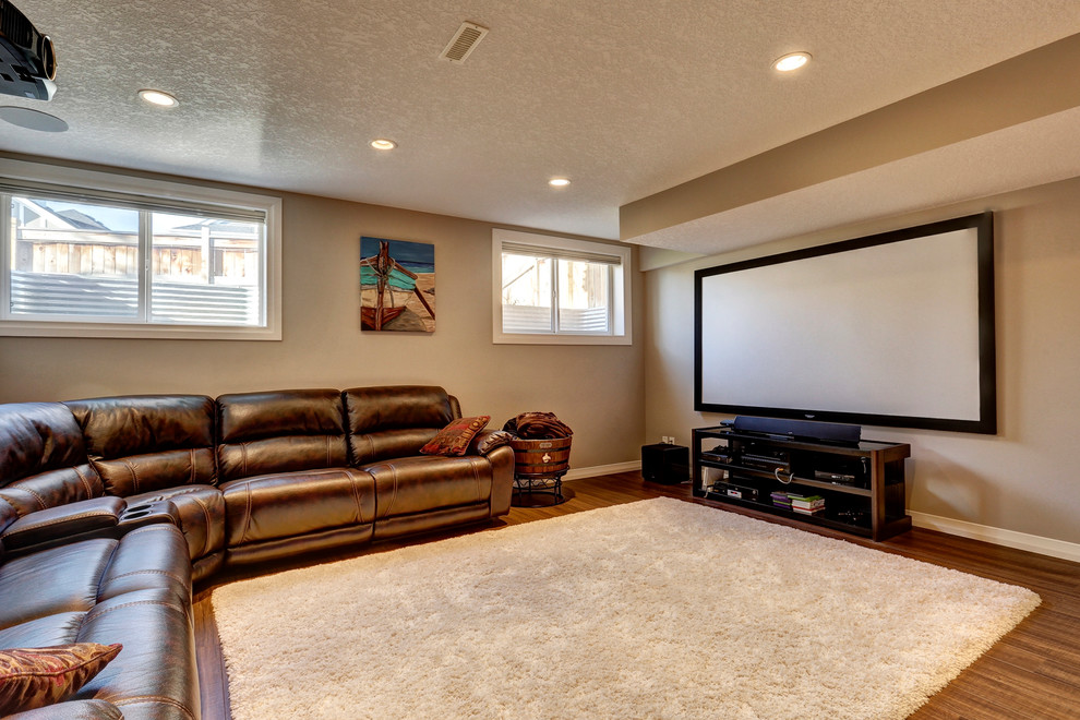 Inspiration for a mid-sized transitional home theatre in Calgary with brown walls and medium hardwood floors.