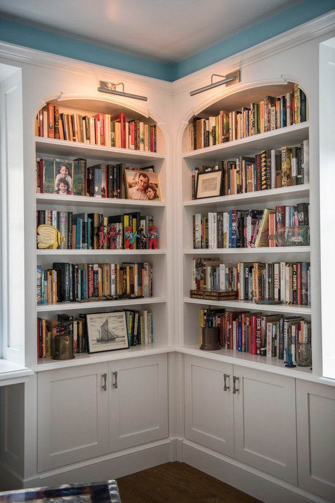 Inspiration for a mid-sized traditional home office in New York with a library, blue walls, medium hardwood floors, no fireplace and brown floor.
