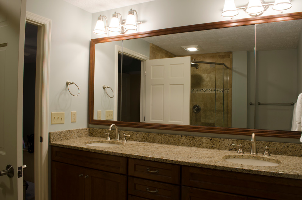 Example of a transitional master porcelain tile alcove shower design in Cincinnati with recessed-panel cabinets, medium tone wood cabinets, a two-piece toilet, an undermount sink and granite countertops
