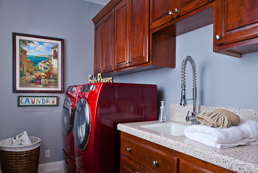 This is an example of a mid-sized contemporary galley dedicated laundry room in Miami with an undermount sink, raised-panel cabinets, dark wood cabinets, a side-by-side washer and dryer and blue walls.
