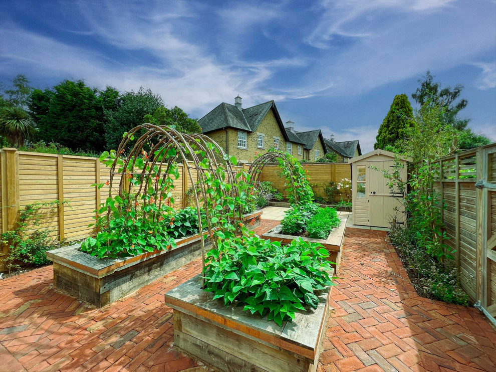 Foto di un giardino vittoriano esposto in pieno sole di medie dimensioni e dietro casa in estate con pavimentazioni in mattoni e recinzione in legno
