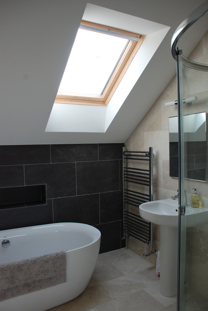 Photo of a contemporary kids bathroom in Cornwall with a freestanding tub, a corner shower, beige tile, limestone, limestone floors, a pedestal sink, beige floor, a sliding shower screen and a single vanity.