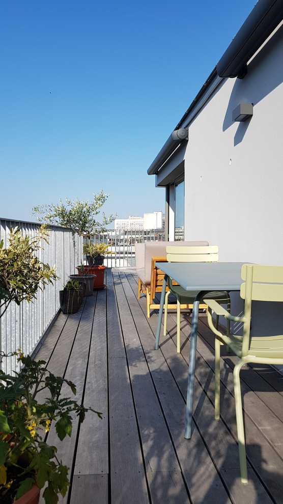 Design ideas for a mid-sized beach style rooftop deck in Nantes with a container garden and a pergola.