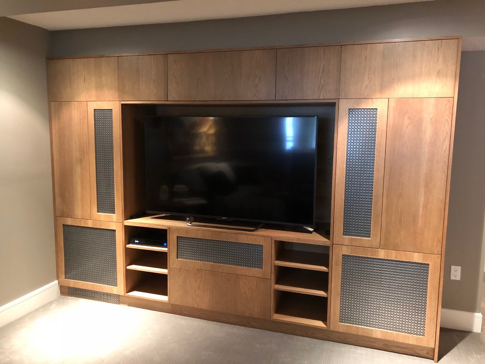 This is an example of a small arts and crafts enclosed home theatre in Calgary with a built-in media wall.