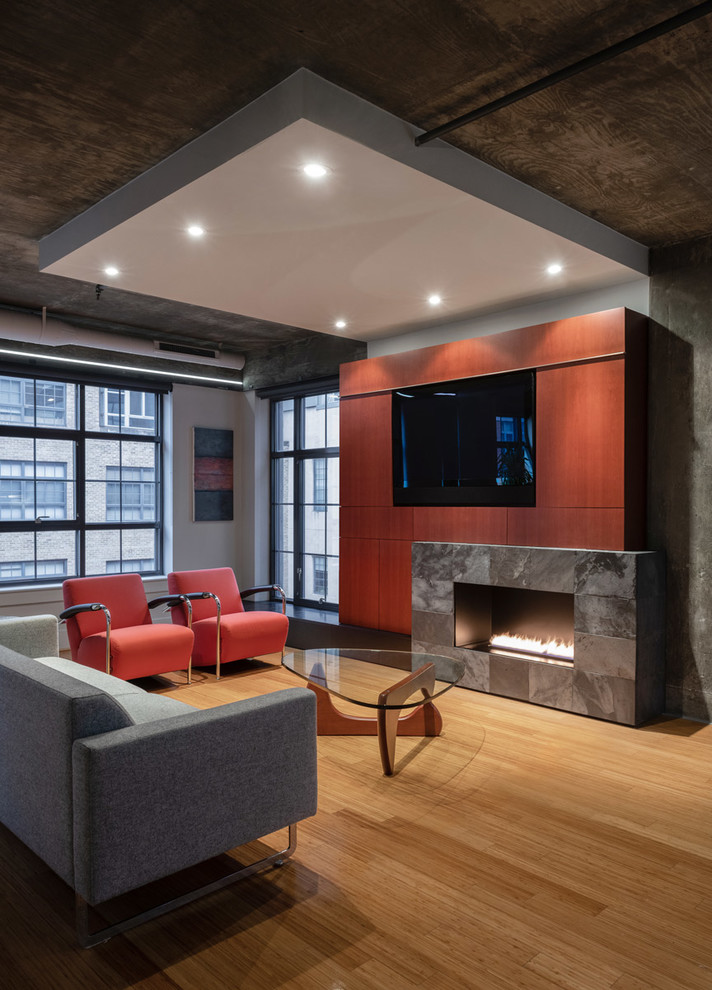 Photo of an industrial living room in DC Metro with light hardwood floors, a ribbon fireplace and a built-in media wall.