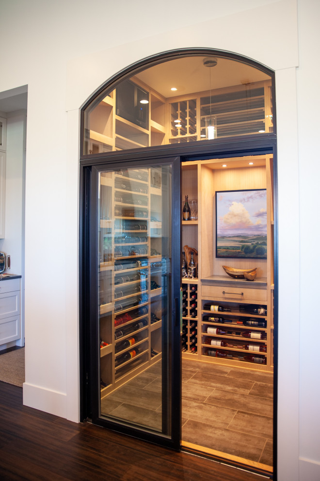 This is an example of a mid-sized modern wine cellar in Seattle with ceramic floors, display racks and beige floor.