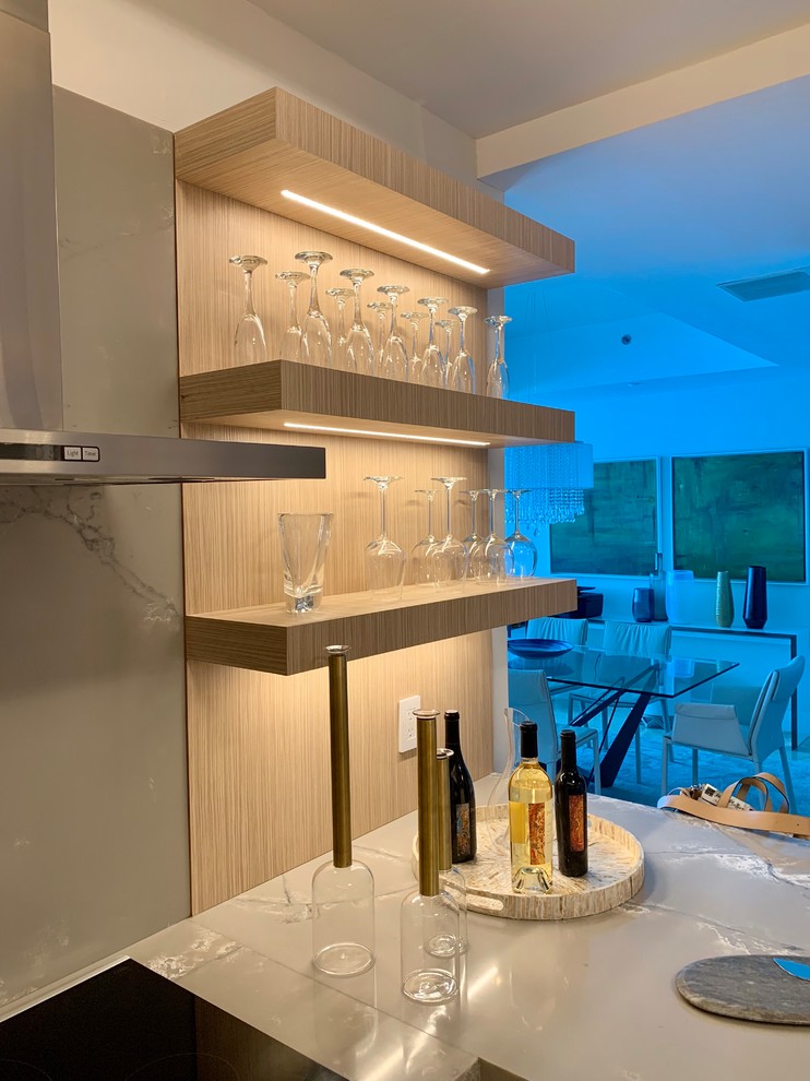 Inspiration for a mid-sized contemporary u-shaped eat-in kitchen in Miami with an undermount sink, flat-panel cabinets, light wood cabinets, quartzite benchtops, grey splashback, stone slab splashback, stainless steel appliances, marble floors, a peninsula, beige floor and grey benchtop.