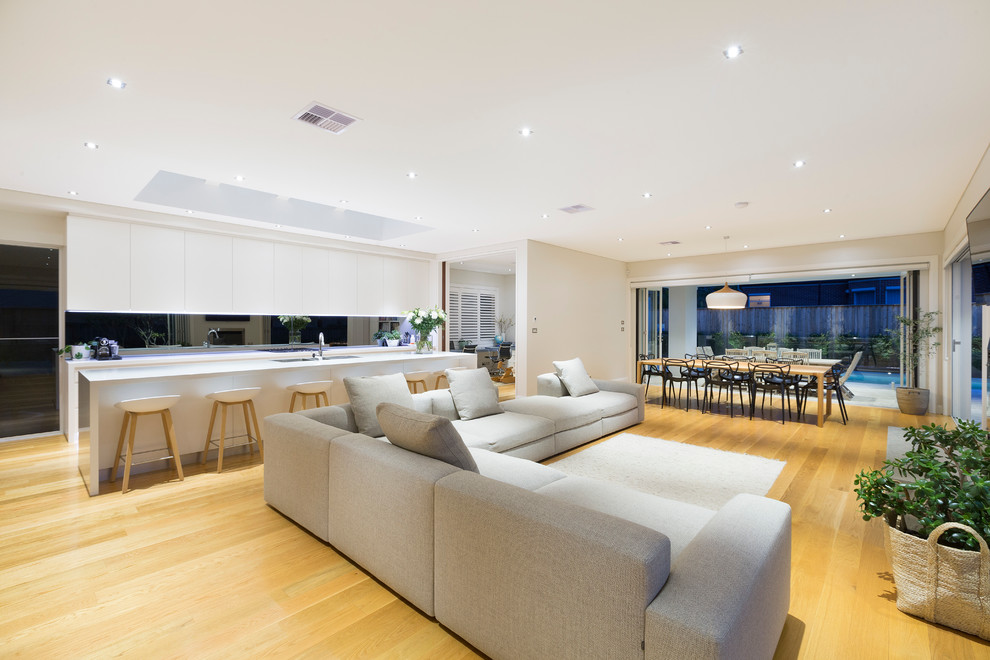 Design ideas for a contemporary open concept living room in Sydney with white walls, light hardwood floors, a ribbon fireplace and a wall-mounted tv.