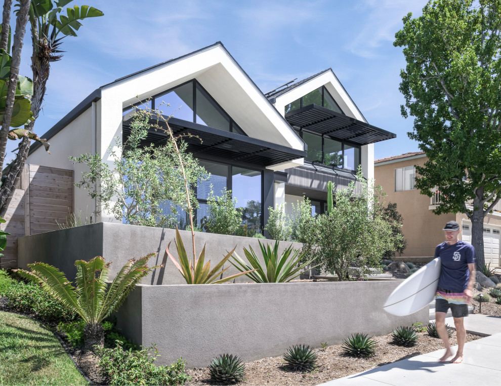 Inspiration pour une façade de maison blanche minimaliste en stuc avec un toit à deux pans, un toit en shingle et un toit noir.