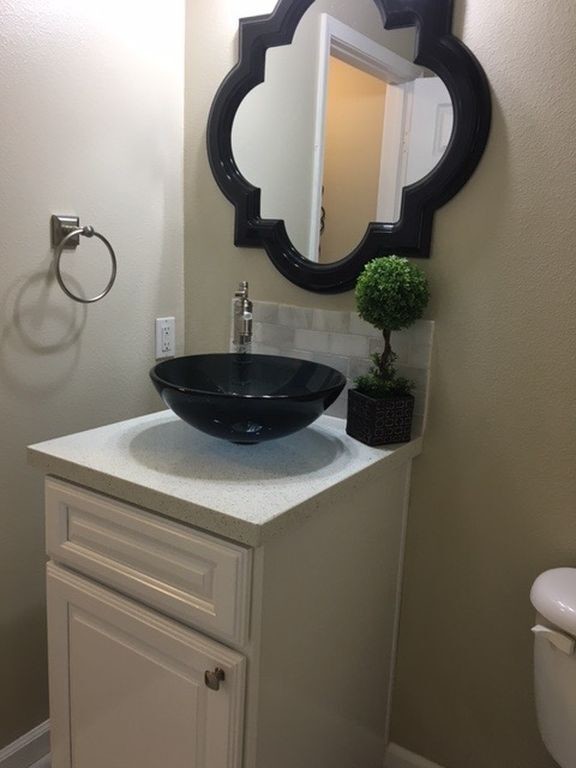 This is an example of a transitional bathroom in Orange County with raised-panel cabinets, white cabinets and a vessel sink.