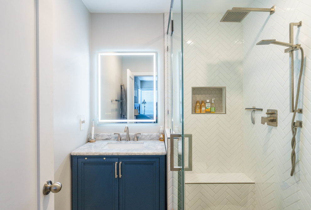 Cette image montre une petite salle de bain principale minimaliste avec un placard avec porte à panneau surélevé, des portes de placard bleues, une douche d'angle, WC séparés, un carrelage blanc, des carreaux de céramique, un mur gris, parquet clair, un lavabo posé, un plan de toilette en marbre, un sol gris, une cabine de douche à porte battante, un plan de toilette blanc, un banc de douche, meuble simple vasque et meuble-lavabo encastré.