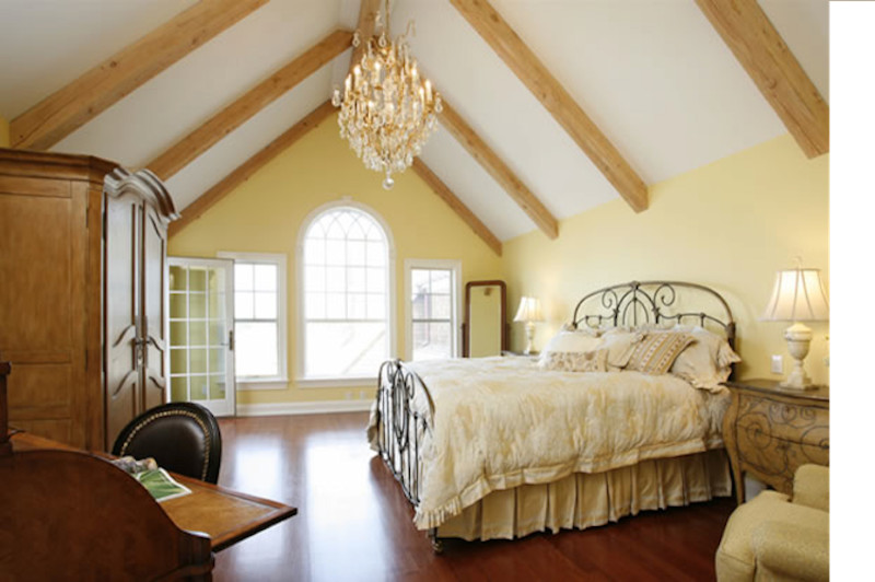 Design ideas for a large country master bedroom in New York with yellow walls, dark hardwood floors and no fireplace.